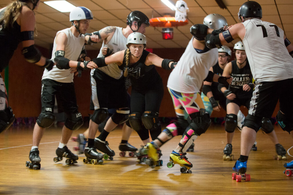 derby players skating in a packed arena, showing intensity and teamwork.